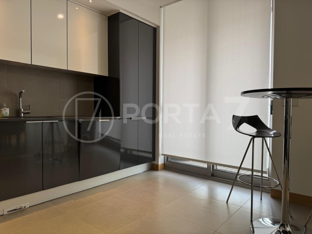 Cozinha com frigorífico embutido e mesa para pequeno almoço