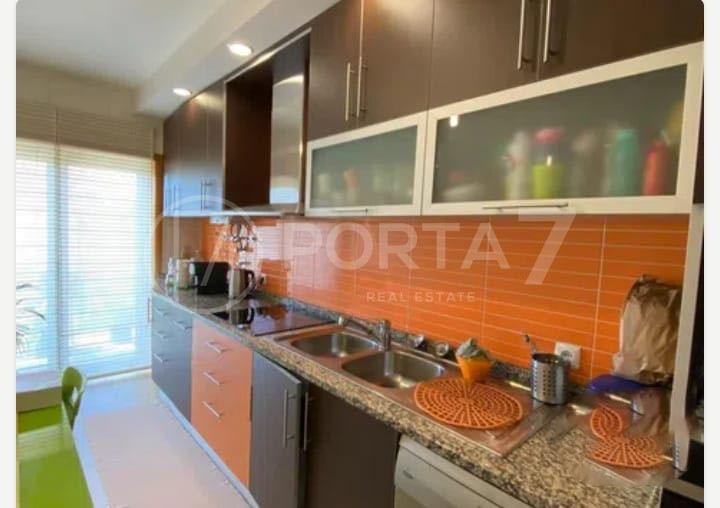 Cozinha equipada com fogão, microondas, placa e frigorífico