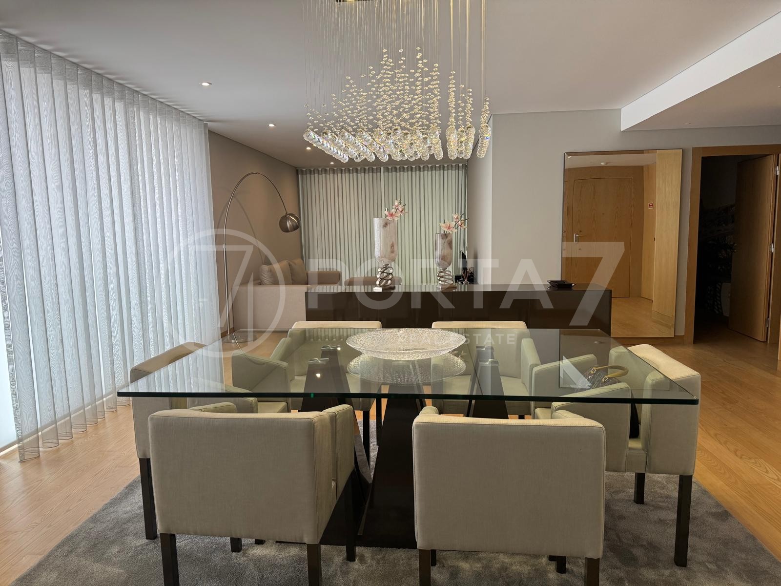Sala de jantar com mesa de vidro e quatro cadeirões