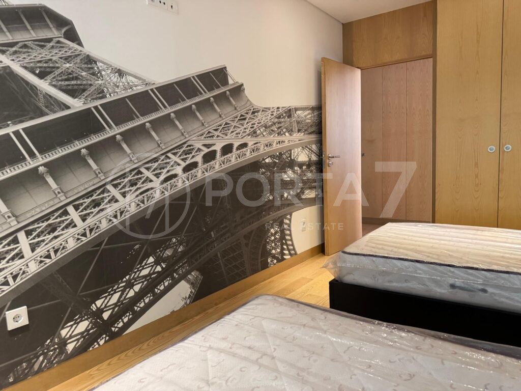 Quarto com duas camas de solteiro e um papel de parede