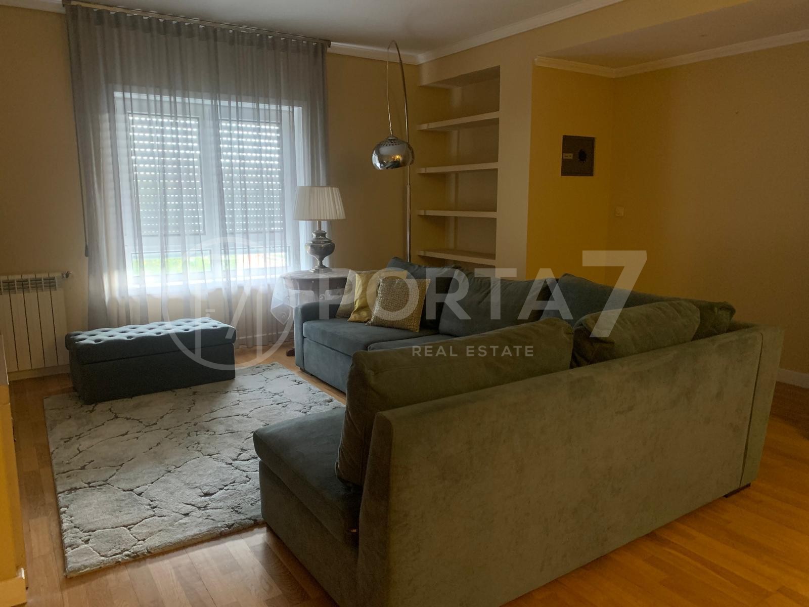 Sala, onde é possível observar u sofá de grandes dimensões